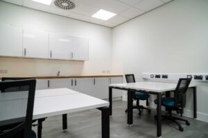 Interior of the 'incubator' meeting room showing desks and a small kitchen area.
