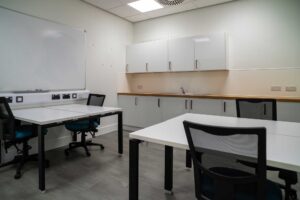 Interior of the 'incubator' meeting room showing desks and a small kitchen area.