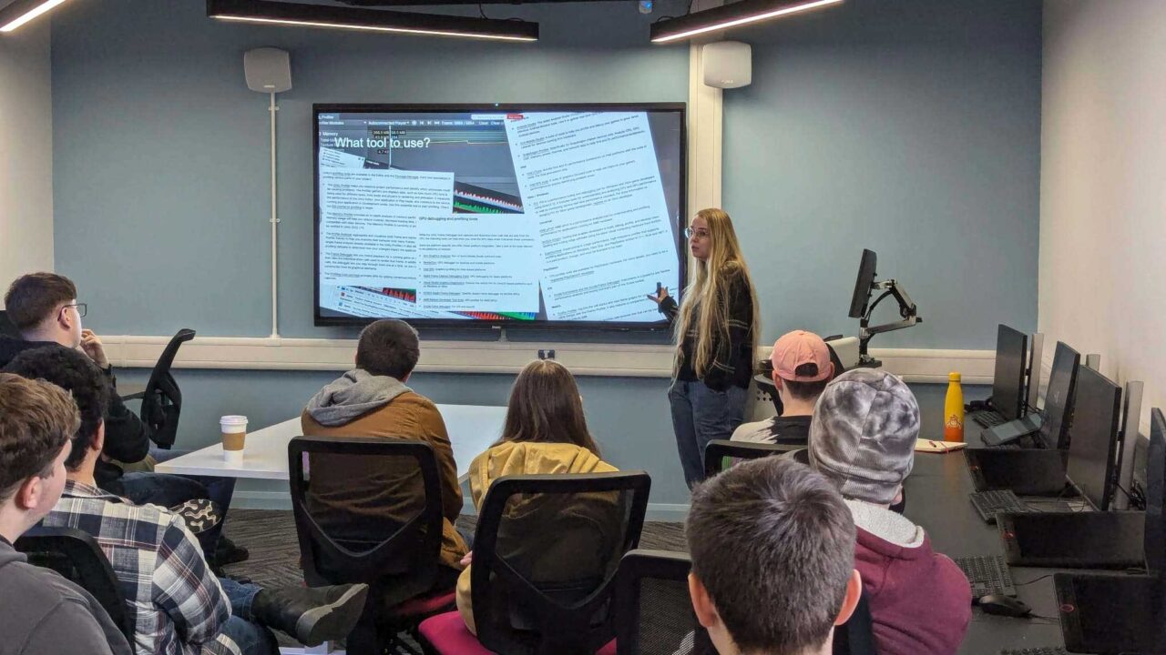 A guest lecturer gives a presentation to a room of students.