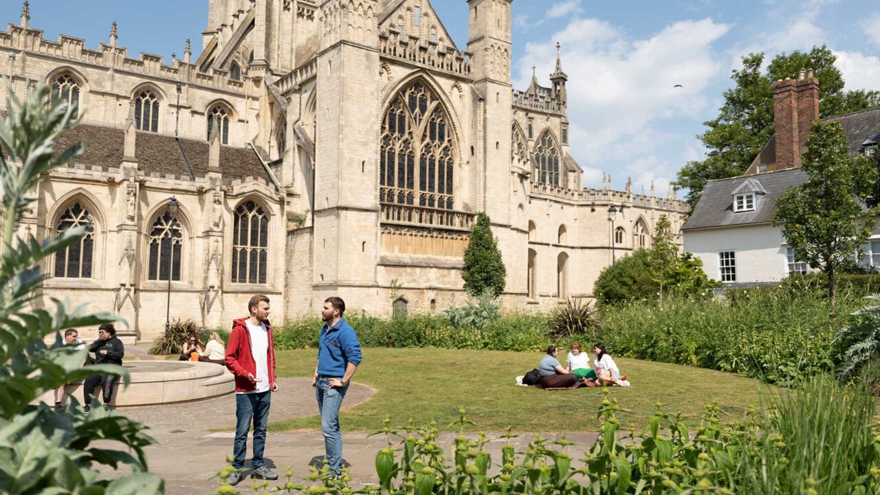 Students socialising in the grounds of Gloucester Cathedral.