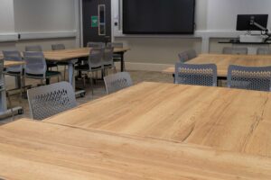 City Campus classroom set up with tables, a screen and computer at the front.