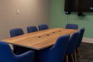 Meeting room at City Campus set up with a table and 9 chairs.