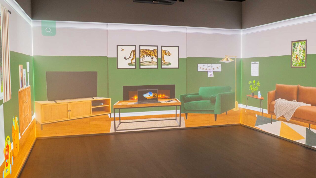 City Campus' immersive room with a virtual living room set up projected onto all walls.
