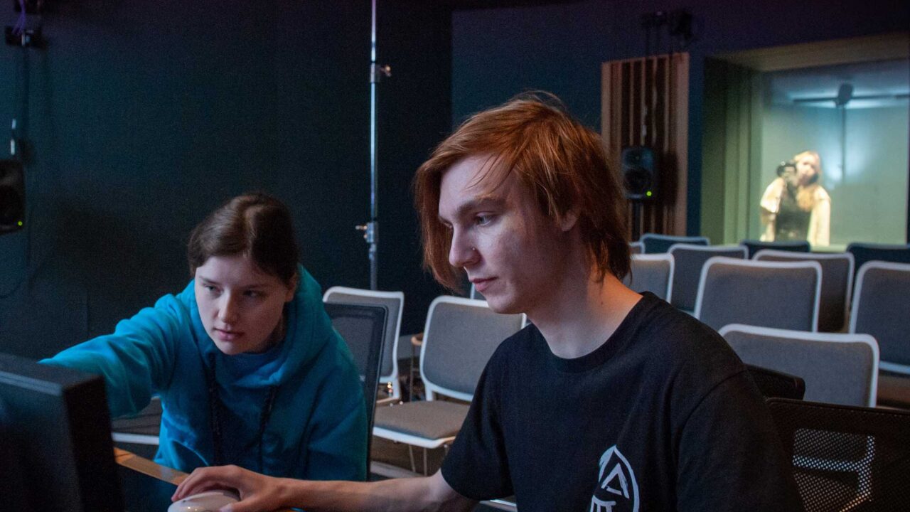 Two students use a mixing desk in the Dolby Atmos Dubbing Theatre