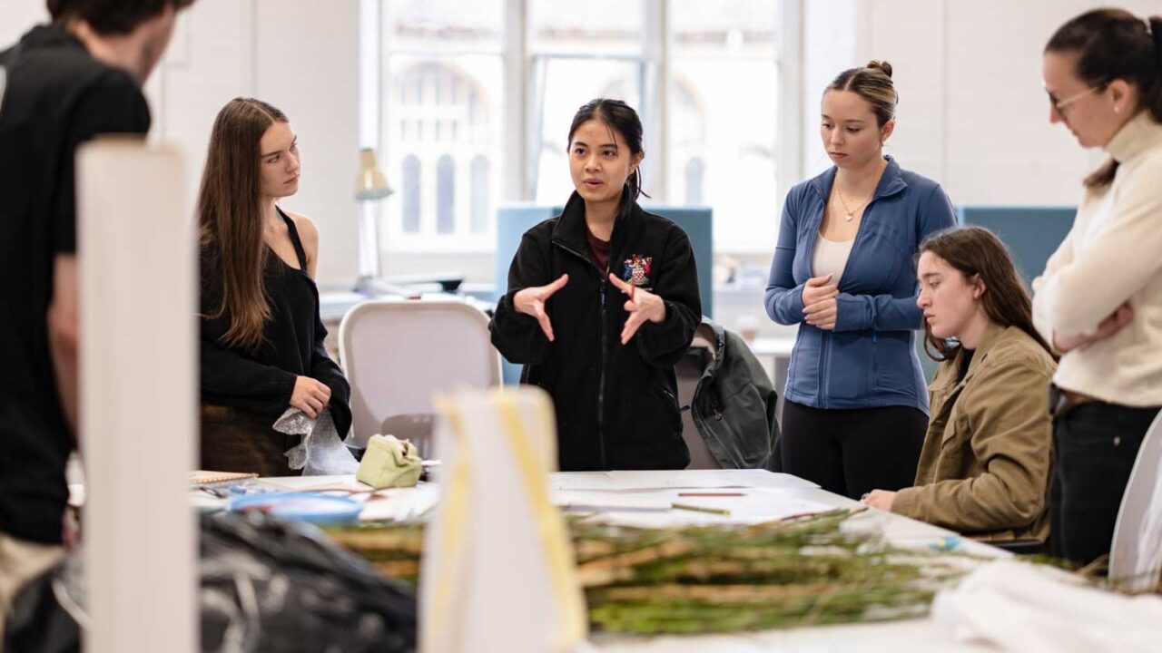 A student talking to others in the architecture studio.