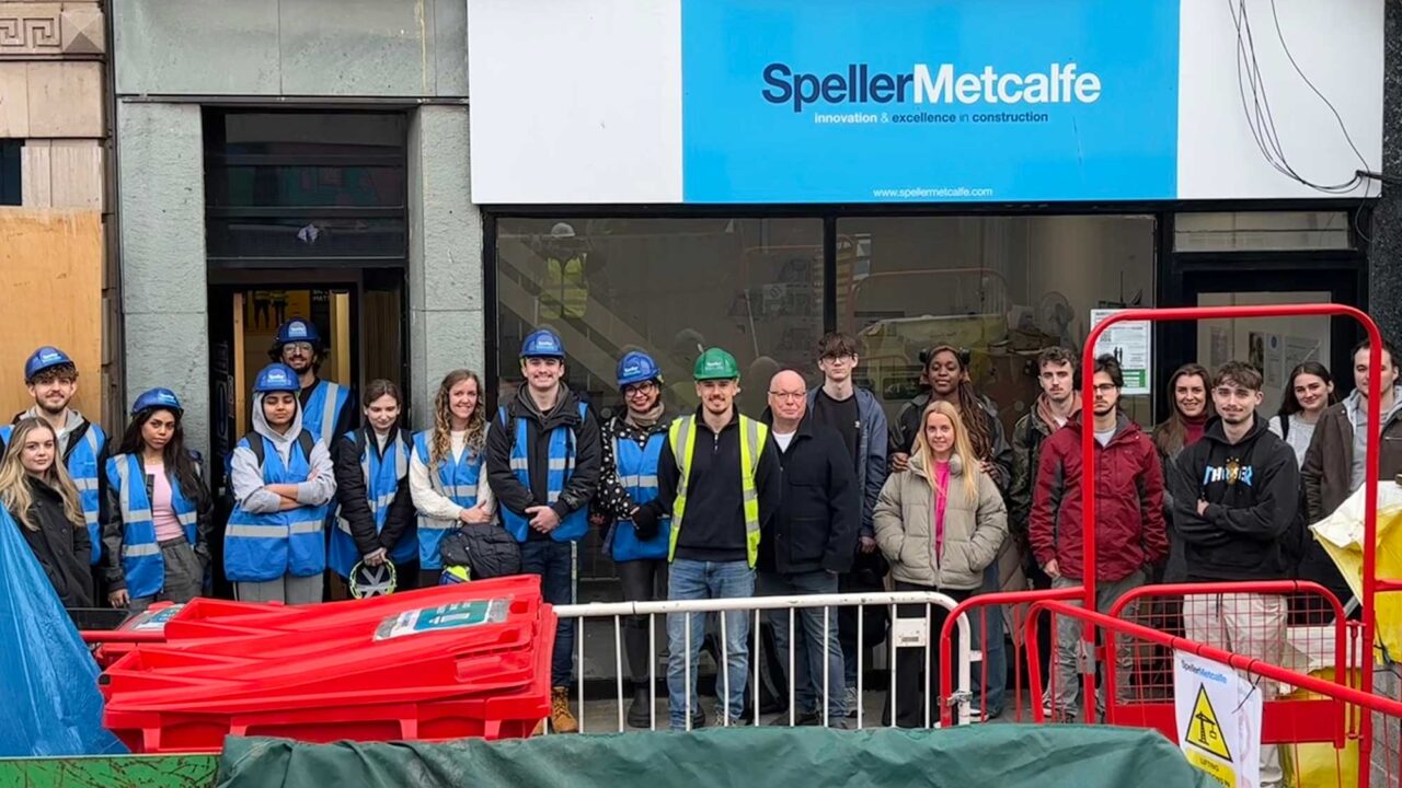 A group of students pose for a photo on a site visit.