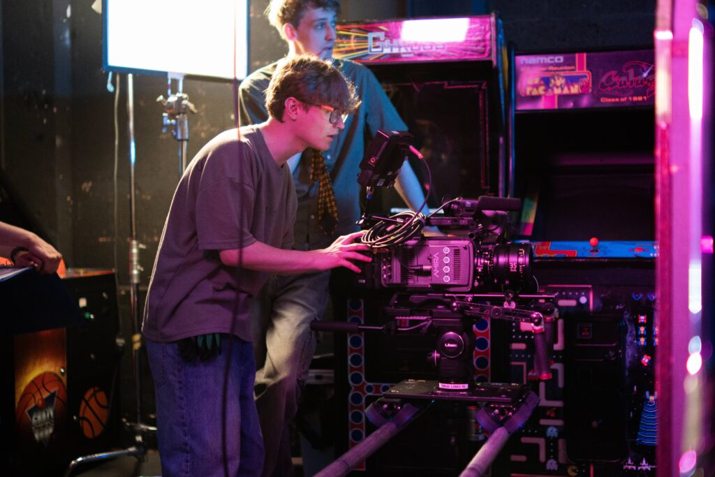 two students operating a TV camera in a dimly lit room