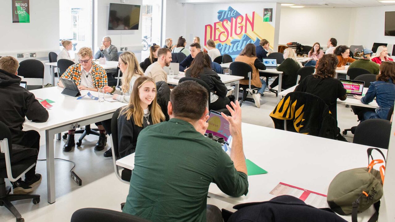 Graphic design students and industry professionals talking to each other at a business meet event.