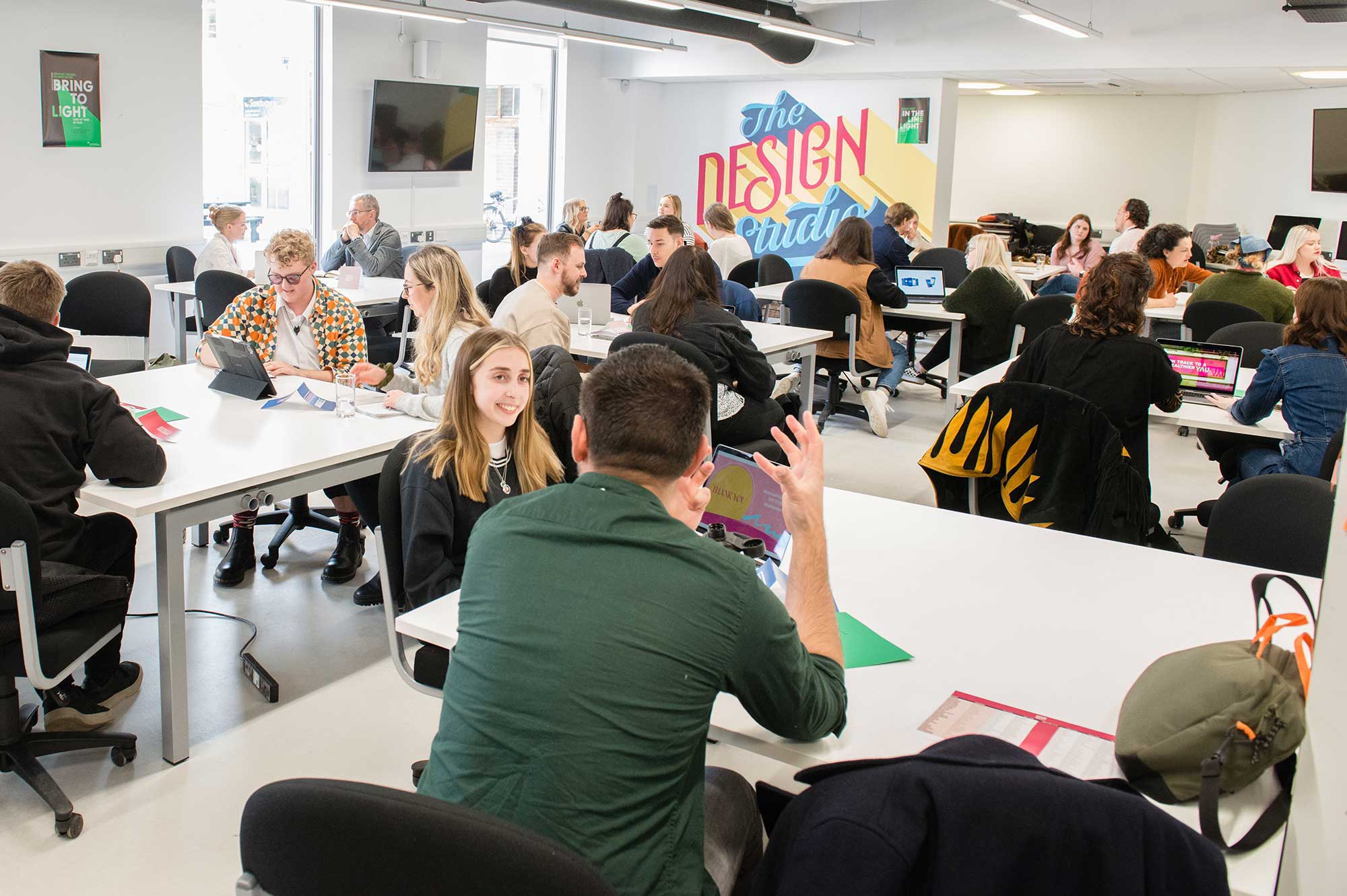 Graphic design students and industry professionals talking to each other at a business meet event.