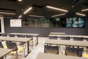 An CGI visual of the interior of FutureSIM showing a classroom with flat screens at the front.