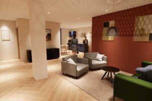 An CGI visual of the interior of FutureSIM showing a seating area and kitchen.