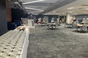 A large open-plan space showing a table with cups and saucers, and tables and chairs.