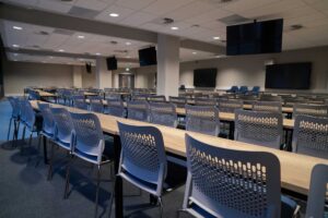 The lecture theatre at City Campus with rows of desks and numerous suspended flat screens.