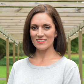 A photo of Natalie smiling outside.