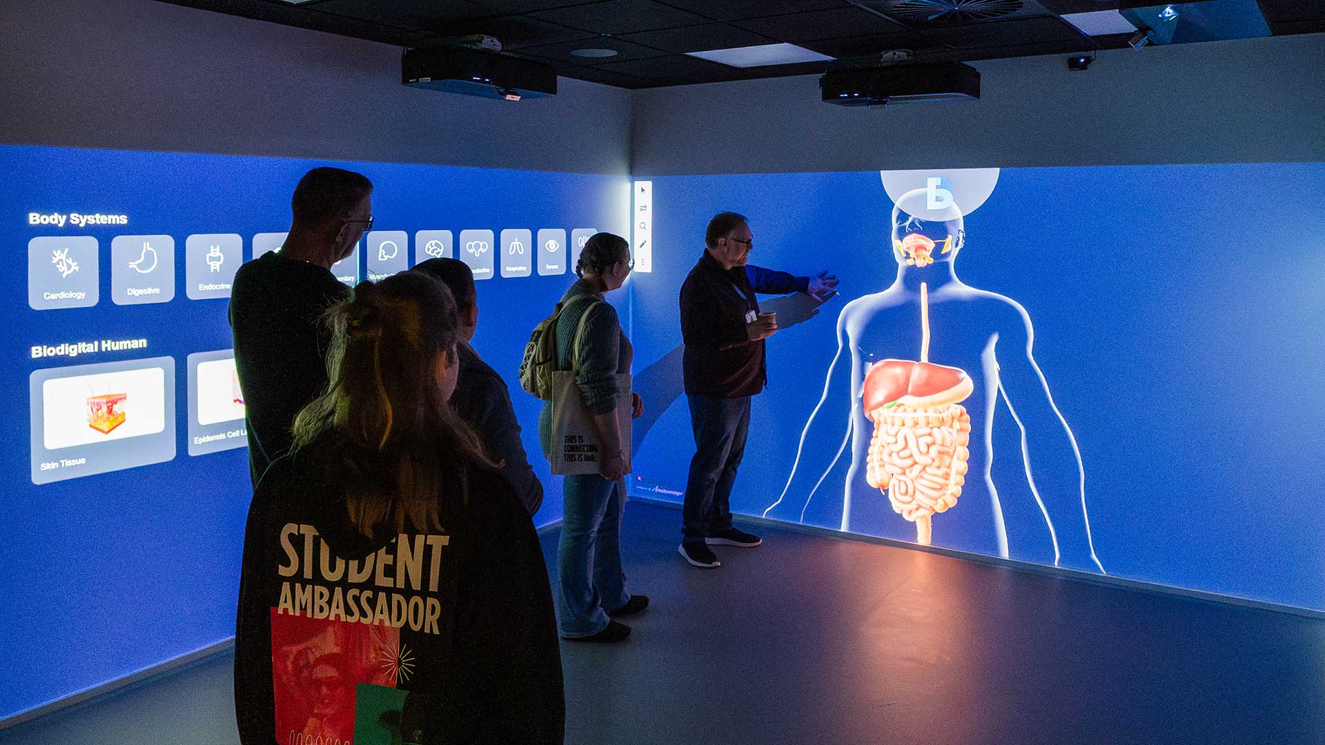 A lecturer showing visitors at an open event how the immersive room works at City Campus.