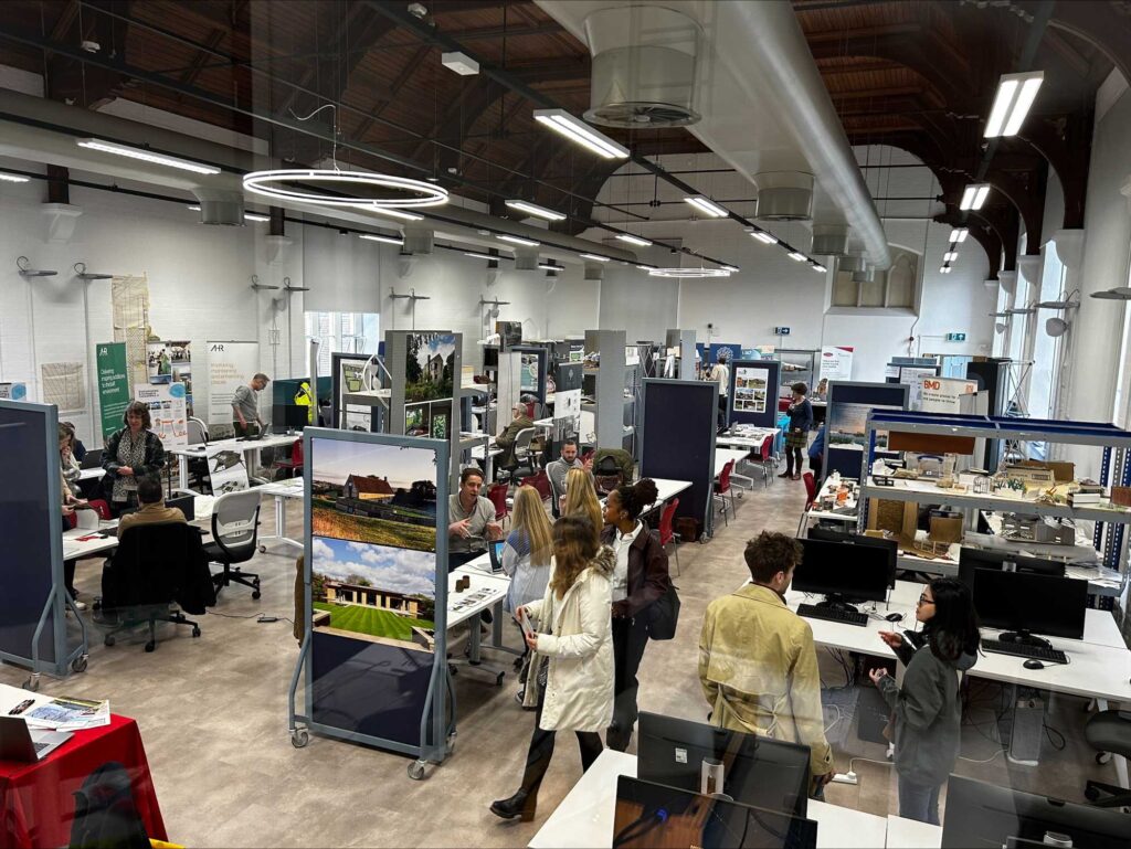 Students in interact with industry professionals in the large architecture studio.