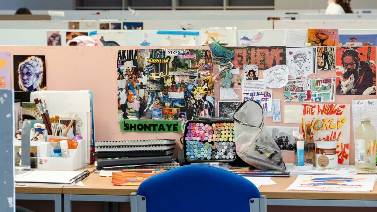 A workspace in the illustration studio showing cartoons, notepads and other art equipment.