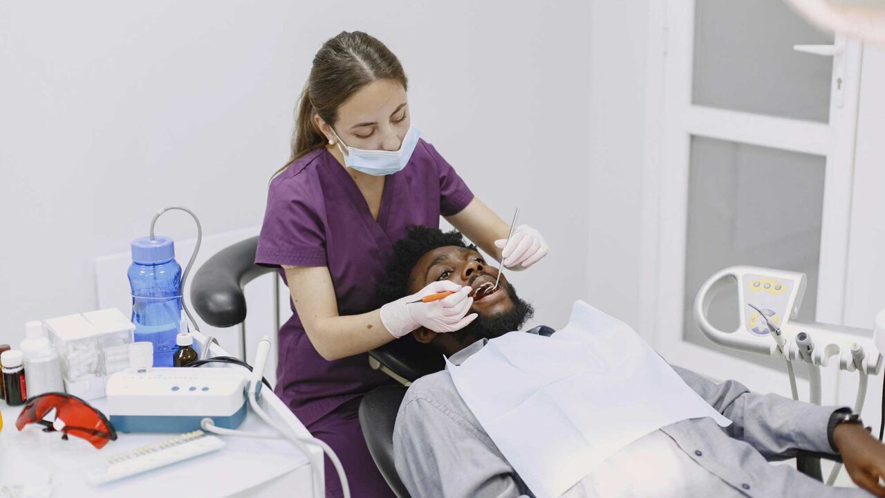 A dental hygienist practising on a patient.