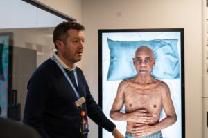 Practice Skills and Simulation Lead, Simon Kearsey, shows a simulated image of a patient lying on a bed in the FutureSIM facility.