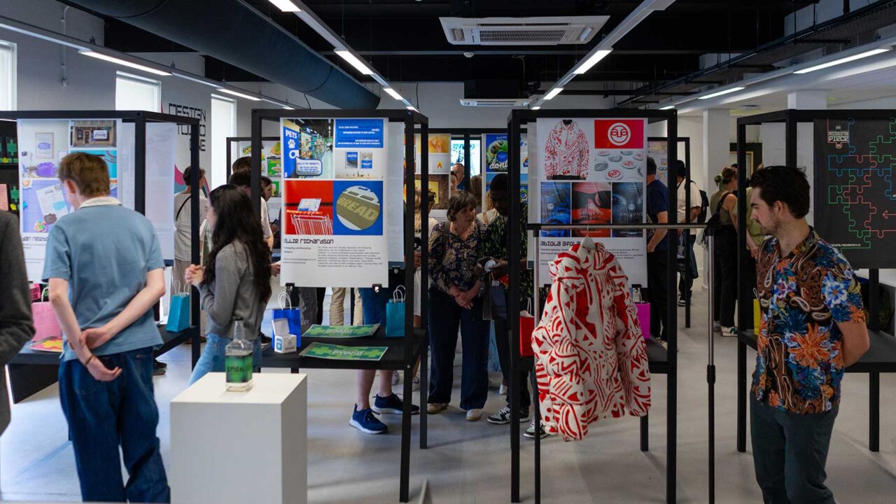 Visitors looking at graphic design work on display at the 2025 degree show.
