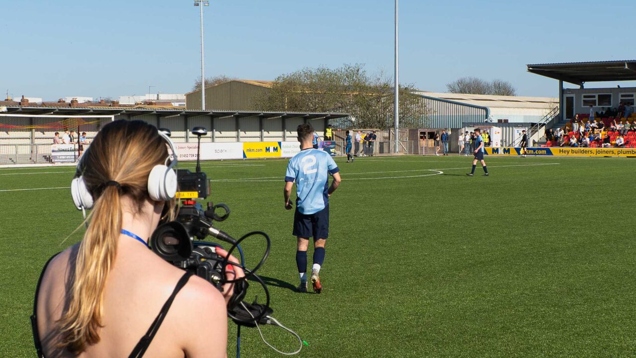 A Sports Journalism student films a Varsity football match.