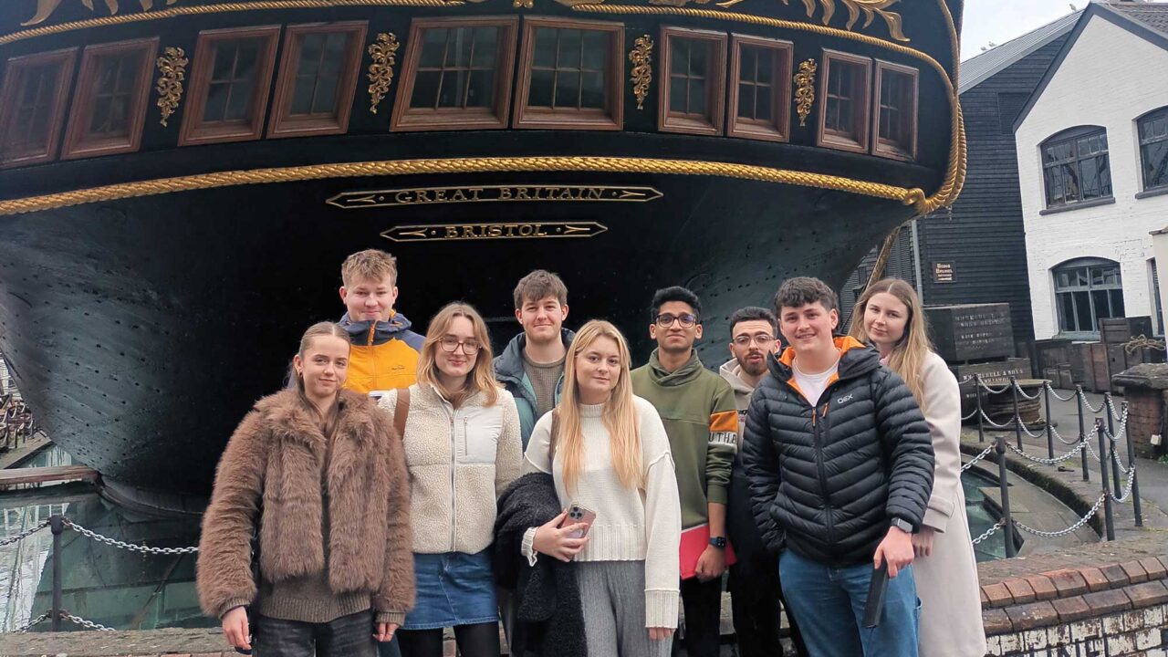 Comms and Media students standing in front of the SS Great Britain in Bristol.