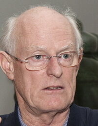 Sir Tony Cragg wearing glasses, a dark blue cardigan and a light blue shirt
