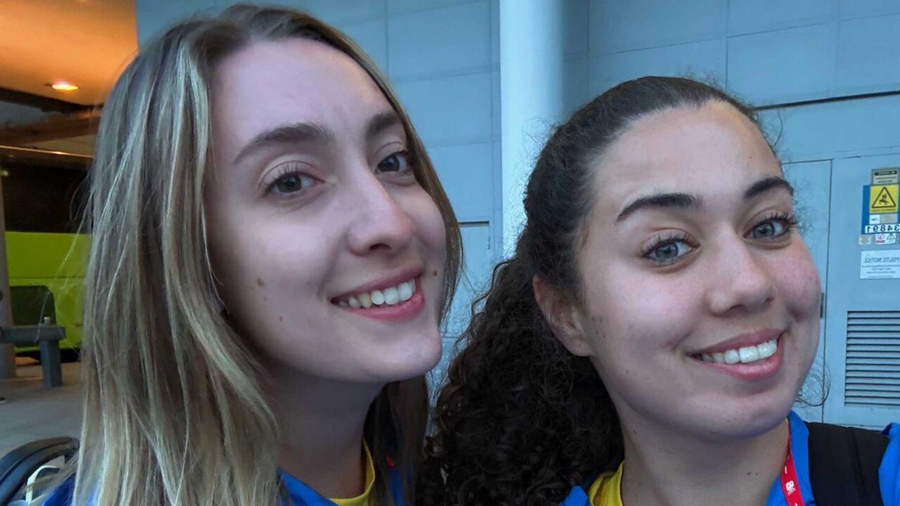 Head and shoulders shot of two Physiotherapy students smiling wearing blue jackets