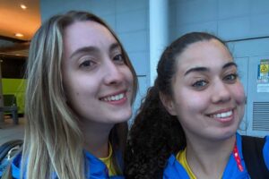 Head and shoulders shot of two Physiotherapy students smiling wearing blue jackets