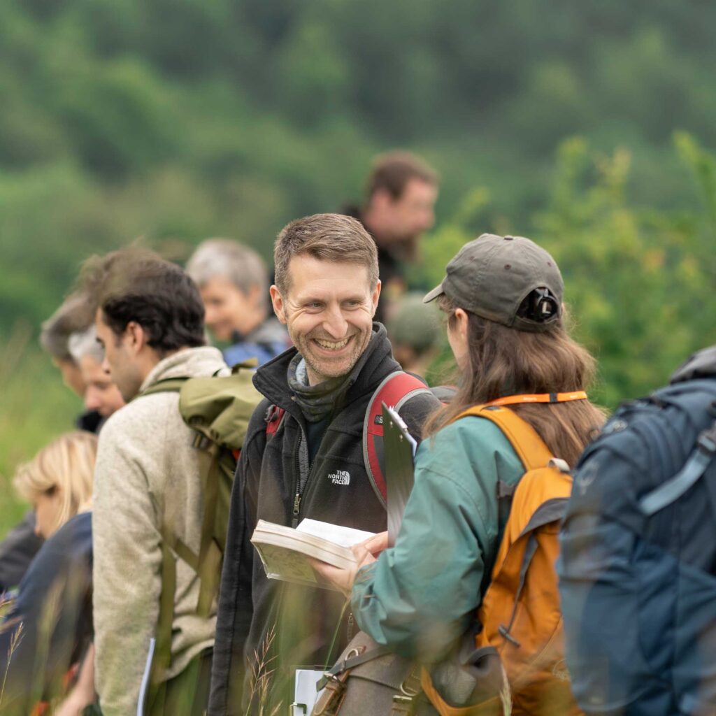 Students on an environmental science field trip to collect ecological data talking to each other.