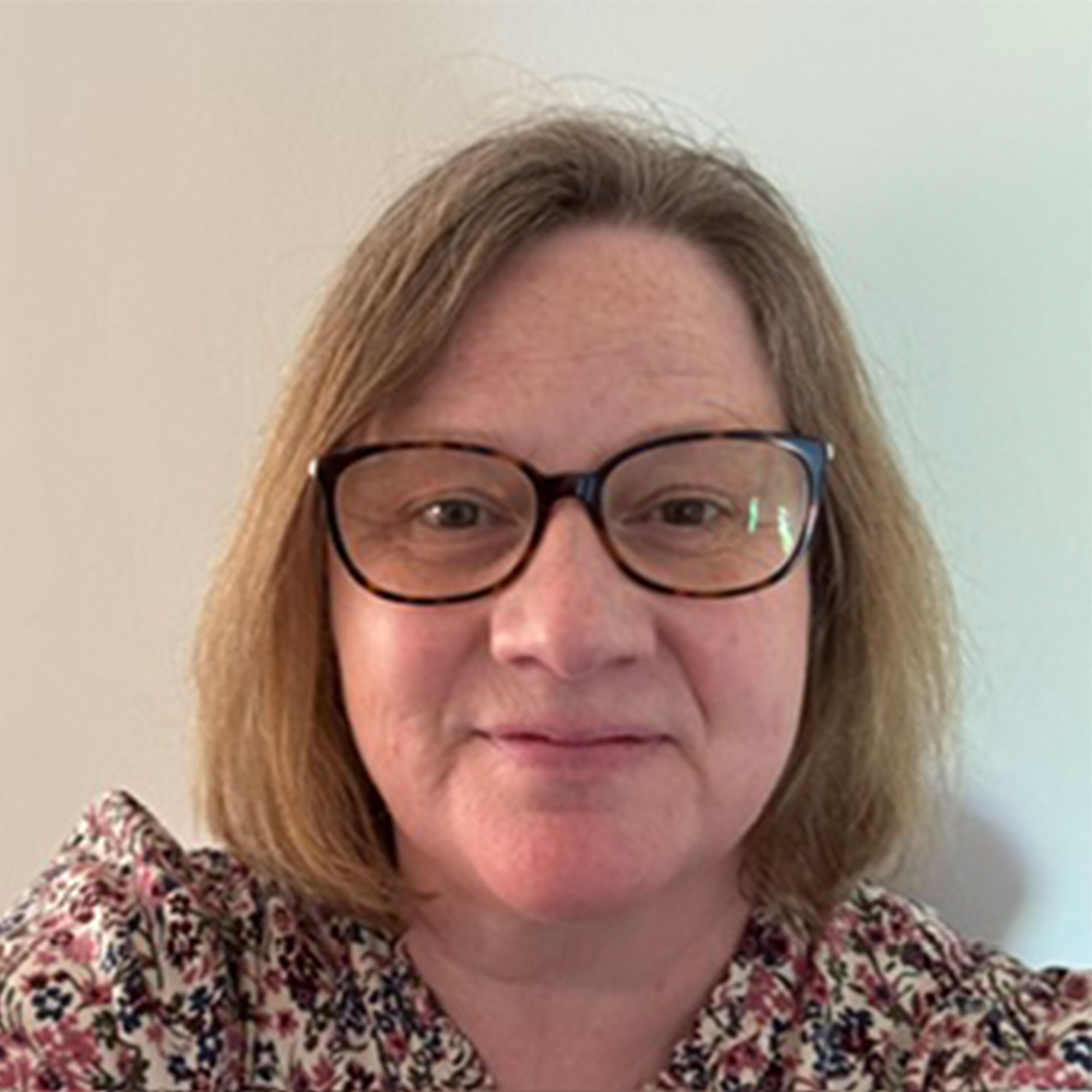 Head and shoulders shot of Julie Wiffen wearing glasses and a floral top.