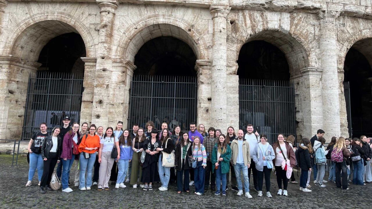 Students on the History trip to Italy pose for a group photo in front of the Colosseum in Rome.