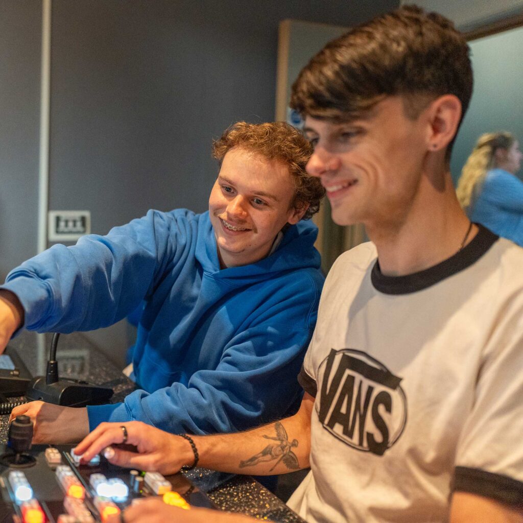 Two students use technical equipment in the media centre.
