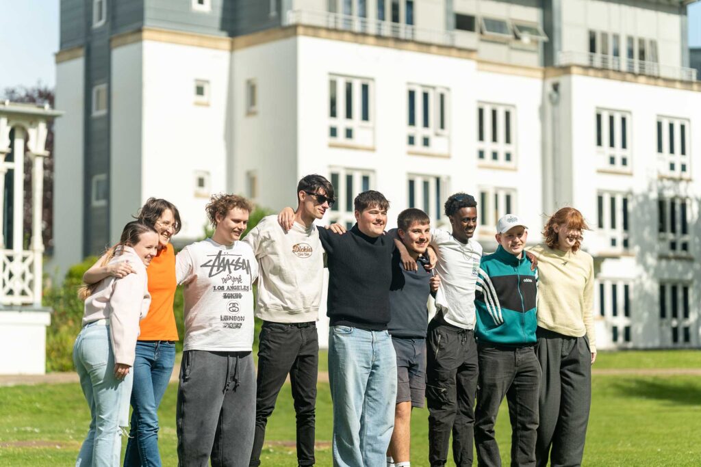 A group of students link arms outside a halls of residence at Park Campus.