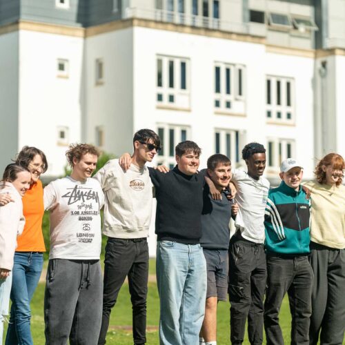 A group of students link arms outside a halls of residence at Park Campus.