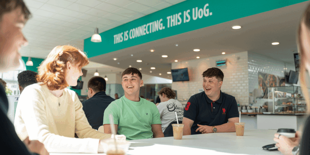 Students in the Park Campus refectory, smiling and drinking coffee.