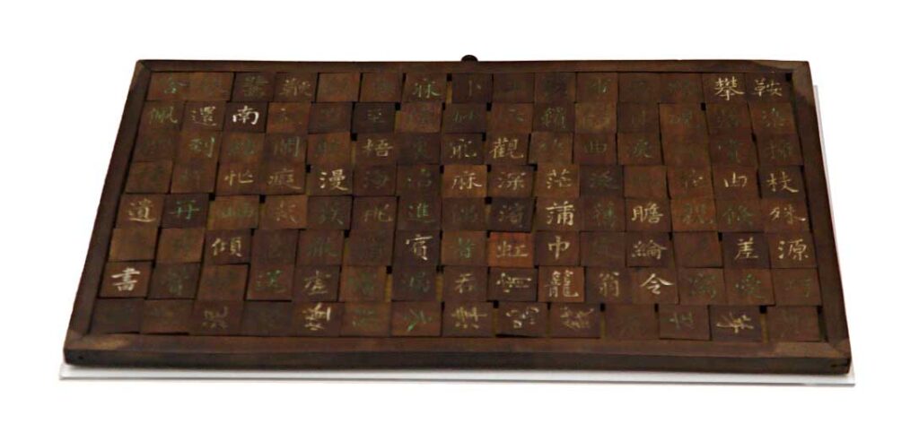 A wooden Chinese game showing square blocks with Chinese lettering on.