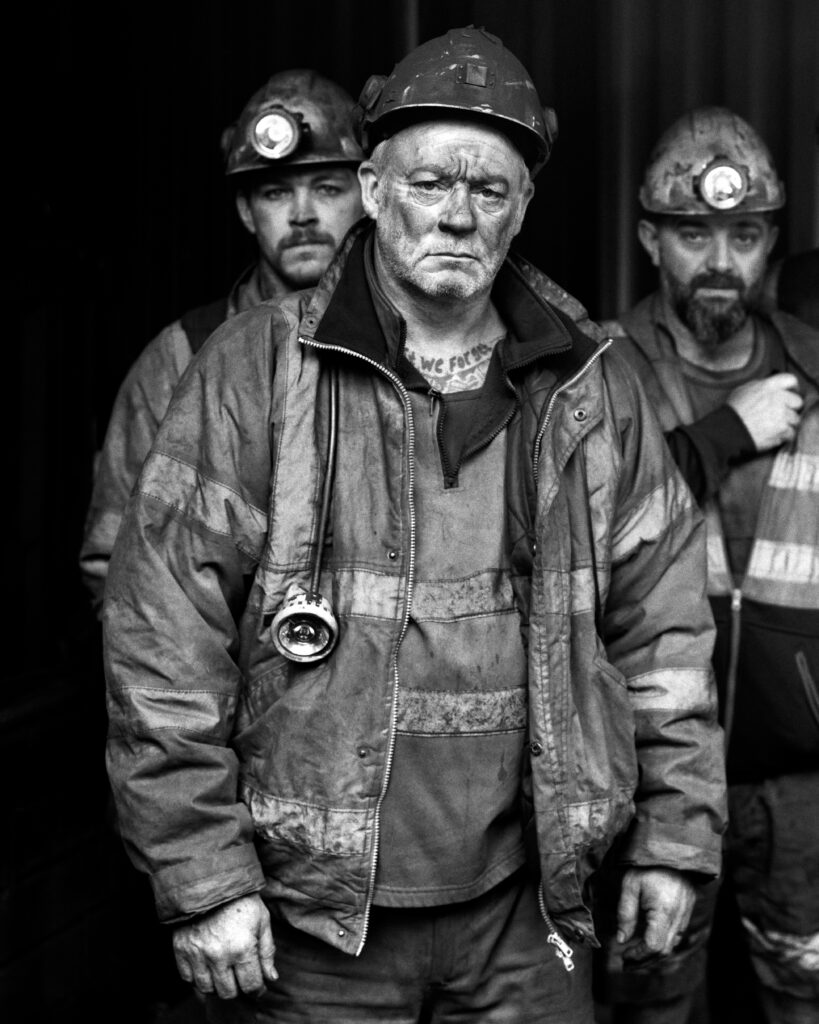 a black and white image of three miners