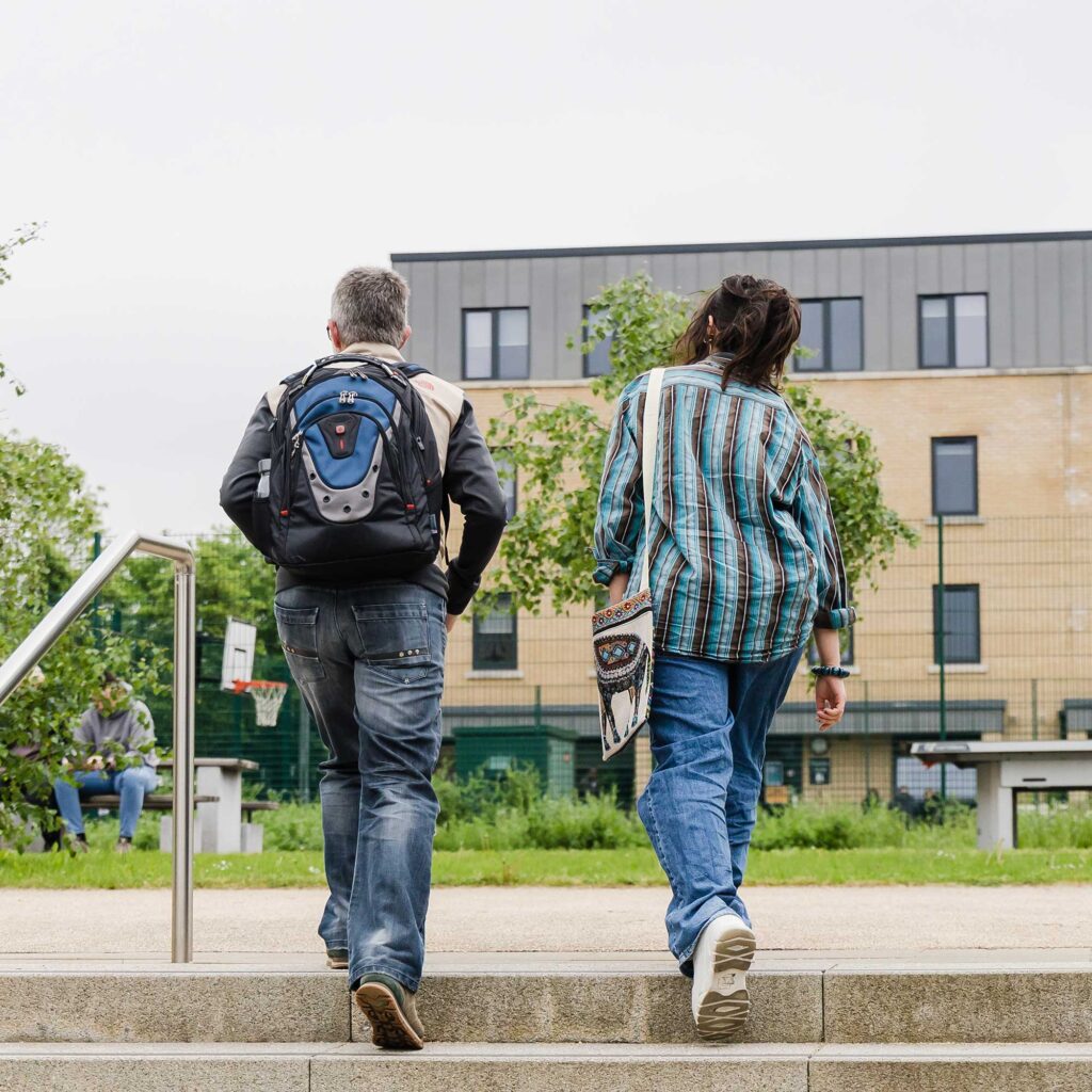 A parent and their parent/carer walk up some steps at Pittville Student Village.