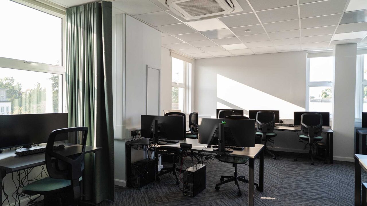 Workstations with computers and desks in a light-filled room in FuturePark.