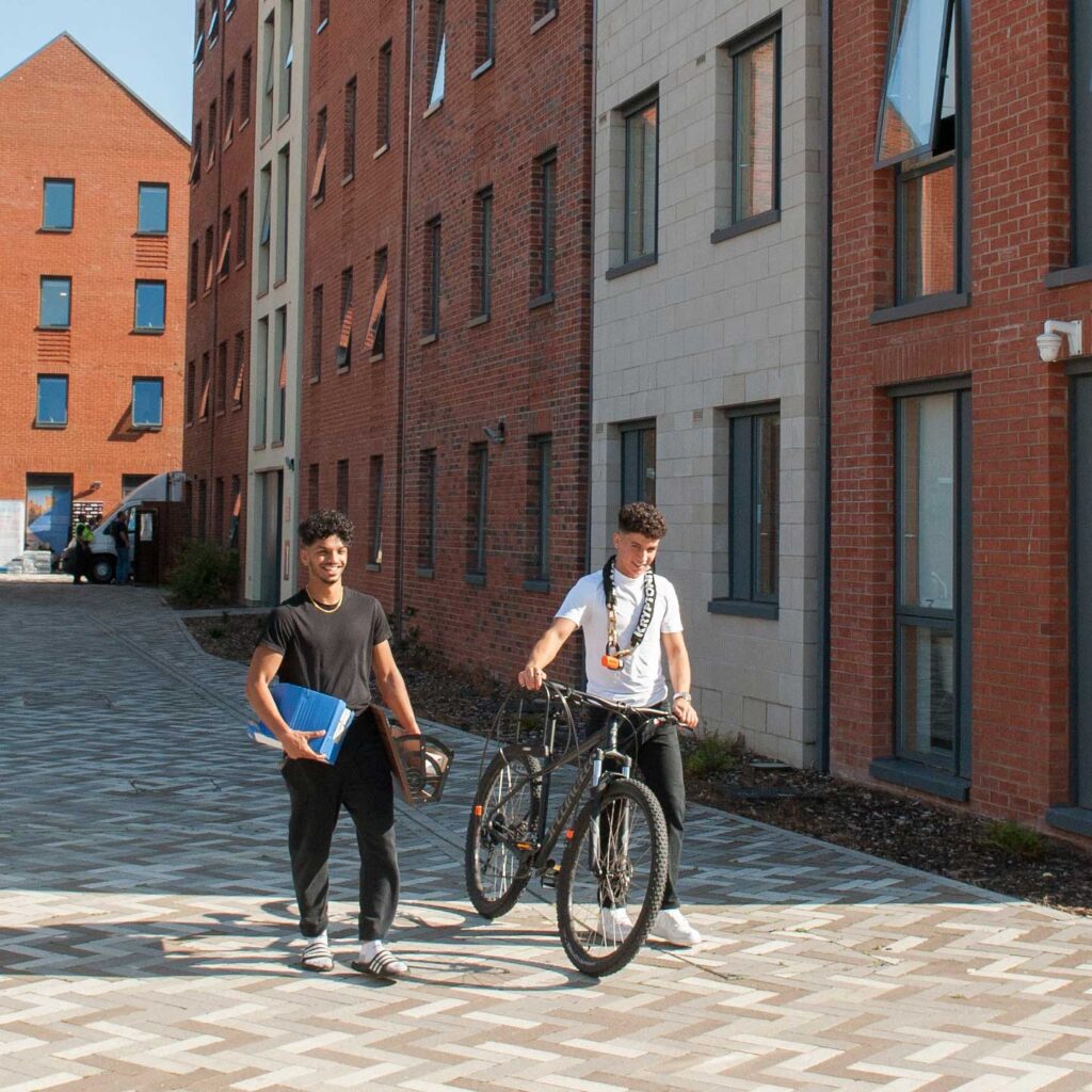 Two students walking on a path at Blackfriars student accommodation in Gloucester.