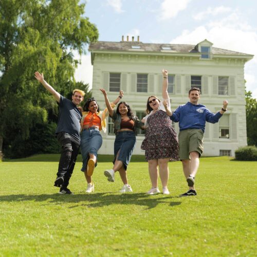 Students with hands raised in a celebratory way at Park Campus.