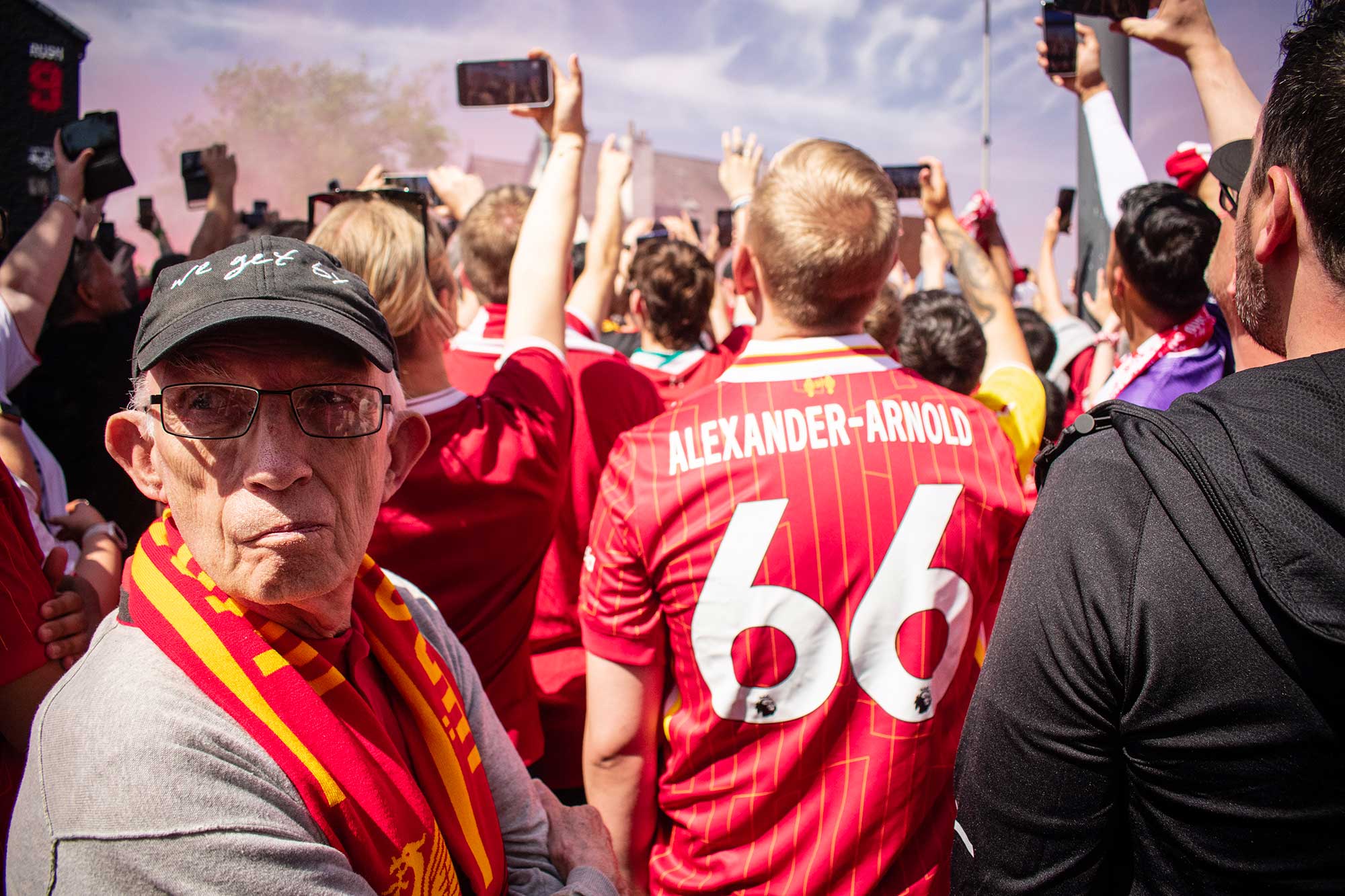 A crowd of football fans holding their mobile phones aloft to film something in front of them.