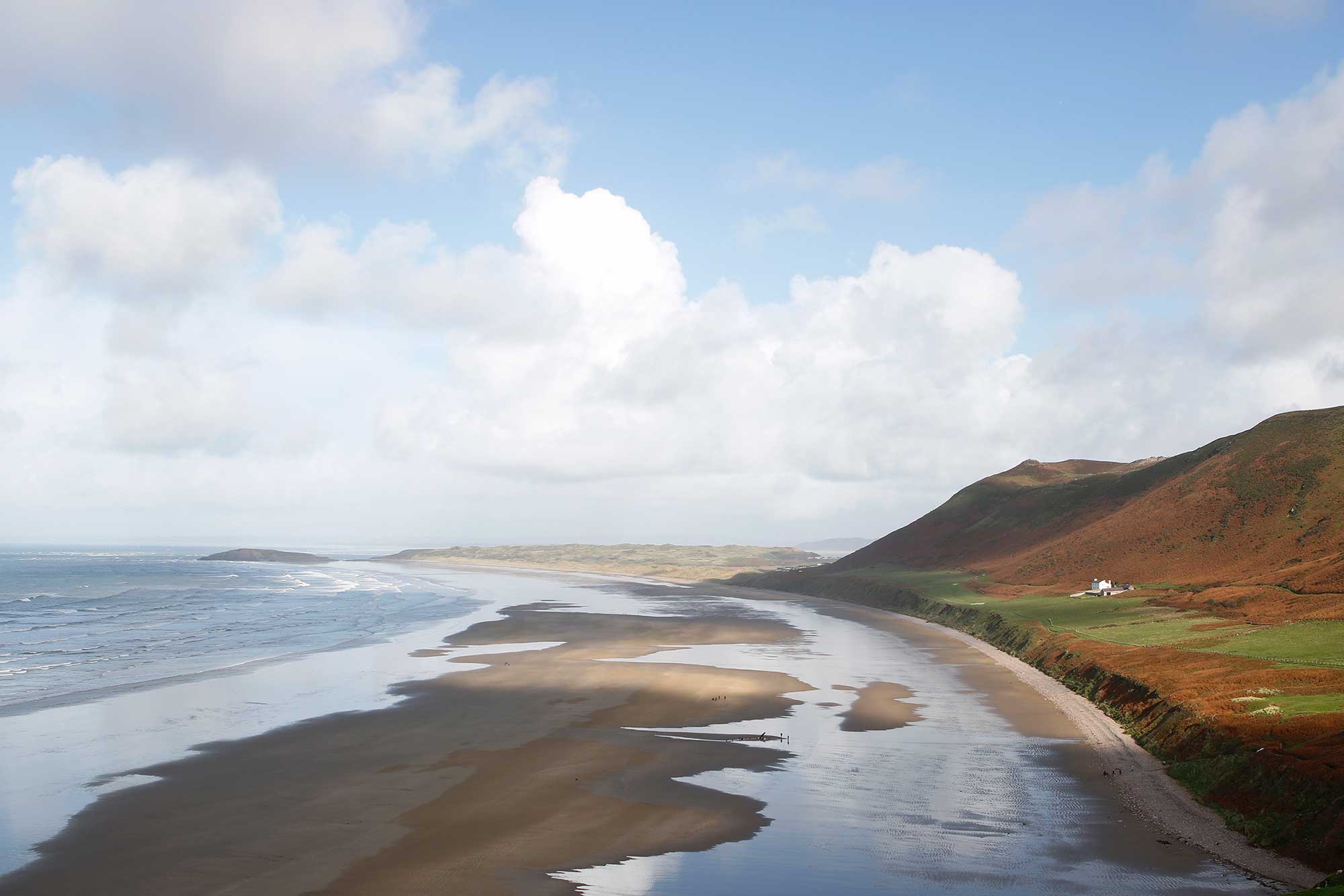 A view of a Welsh beach and coastal landscape.